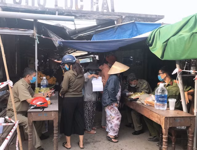 Người dân đi chợ theo ngày bằng phiếu. Ảnh: GĐ&amp;XH.