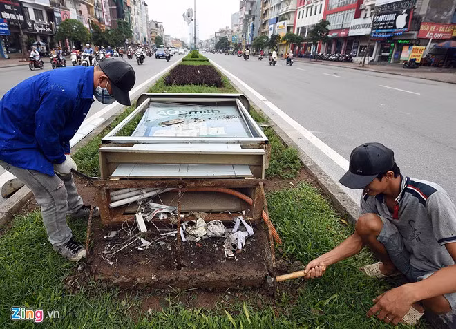 Công nhân khắc phục biển quảng cáo đổ trên đường Đại Cồ Việt.