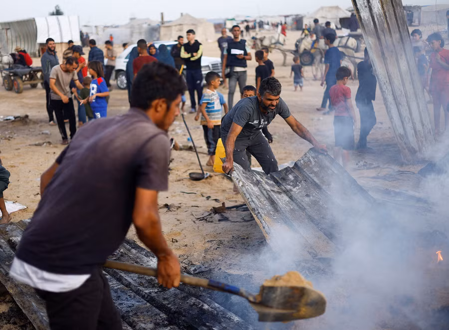 Người Palestine dập lửa tại địa điểm bị Israel tấn công vào khu vực dành cho người di tản ở Rafah, Gaza, ngày 26/5/2024