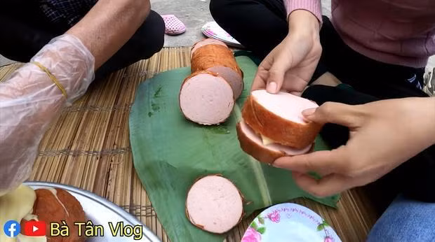 Bà Tân cắt xúc xích to như miếng giò vậy.