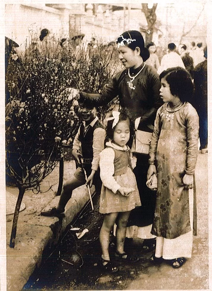 Cùng mẹ đi mua đào Tết trên phố Hàng Lược, Hà Nội (1952). Ảnh: Nguyễn Văn Nhàn.
