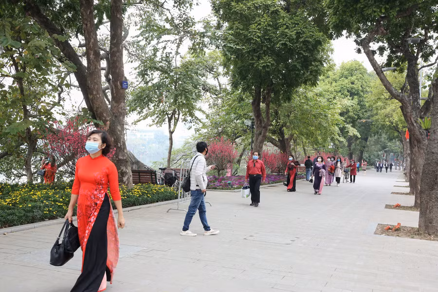 Nhiều người mặc áo dài đẹp, rực rỡ xuống phố du Xuân trong ngày đầu năm mới. Ảnh: VTV.