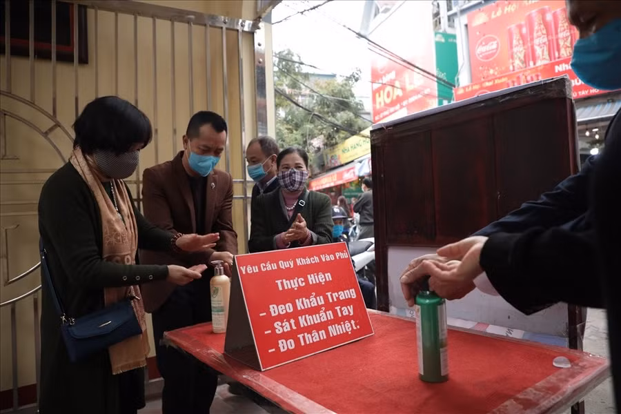 Vào mỗi dịp năm mới, Phủ Tây Hồ thường là nơi đến lễ của đông đảo người dân khắp nơi nhưng sáng mùng 1 Tết năm nay thưa thớt người đến. Tại khu vực này, người dân chấp hành nghiêm việc đeo khẩu trang, rửa tay sát khuẩn trước khi vào. Ảnh: LĐO.
