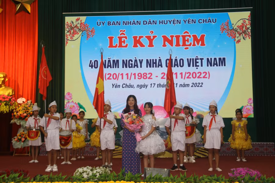 Các em học sinh tặng hoa bà Vũ Thị Tuyết, Trưởng phòng giáo dục huyện Yên Châu.
