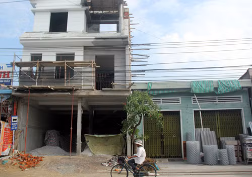 Nhà ông Hiệp (trái) phải ngừng thi công nhiều tháng nay vì hàng xóm kiện đòi lại 27 cm đất mặt đường. Ảnh. Tiến Hùng. dai-gia-loi-hang-xom-ra-toa-vi-27-cm-dat-mat-duong
