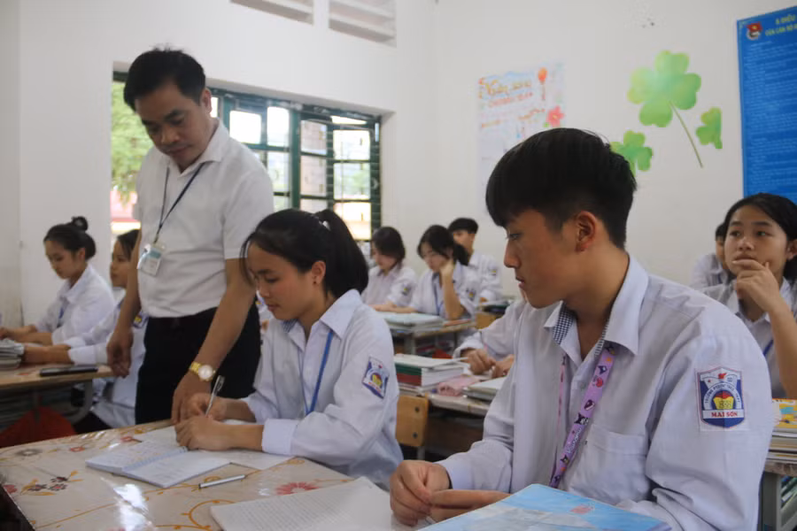 Thầy Hiệu kiểm tra bài học của học sinh.