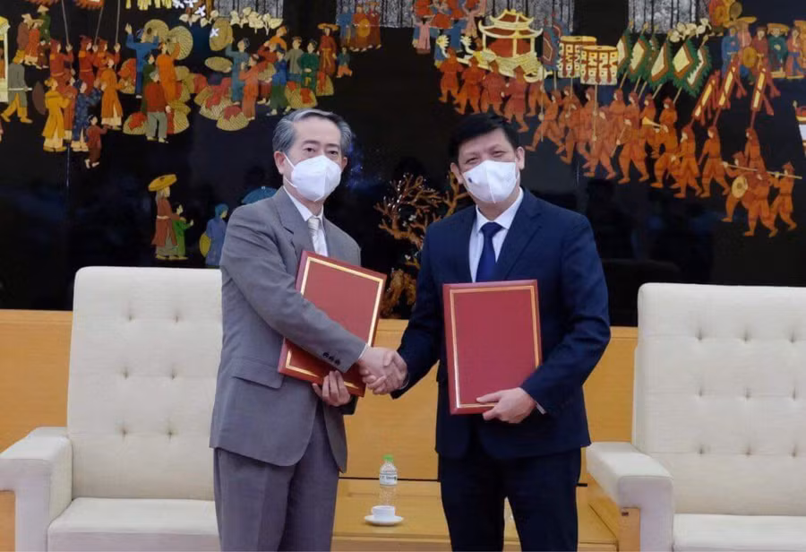 GS.TS Nguyễn Thanh Long - Bộ trưởng Bộ Y tế Việt Nam và ngài Hùng Ba - Đại sứ đặc mệnh toàn quyền nước CHND Trung Hoa - trao biên bản bàn giao lô hàng viện trợ gồm 500.000 liều vắc xin và hơn 500.000 bơm kim tiêm. Ảnh: BYT.