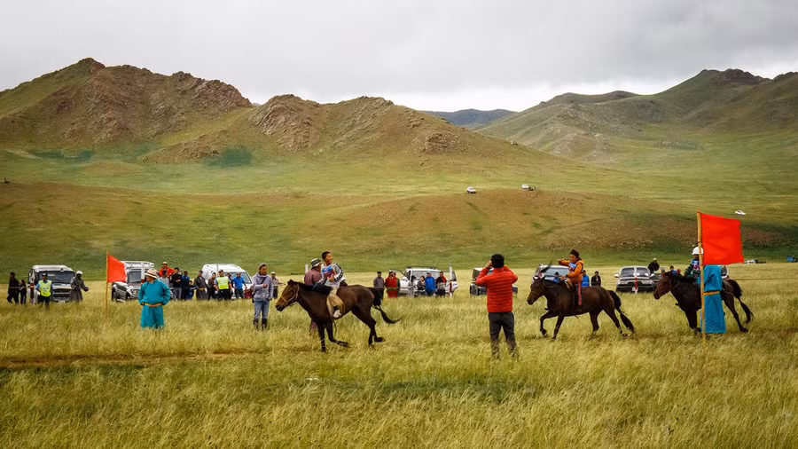 Những nài ngựa vượt qua vạch đích trong một lễ hội Naadam ở Uliastai, phía Tây Mông Cổ. Ảnh: CNN