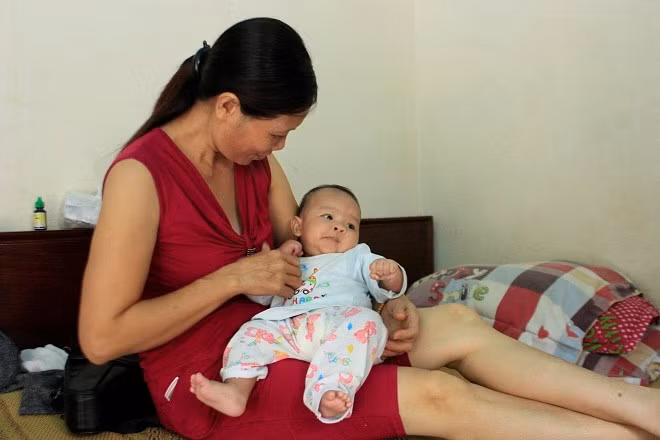 Bé gái 3 tháng tuổi trong vòng tay bà Mai. Ảnh: Phương Chi