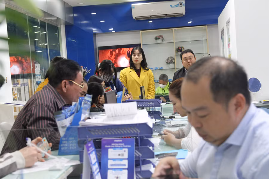 Ghi nhận người dân làm thủ tục chuẩn hóa thông tin thuê bao di động tại điểm giao dịch của nhà mạng Vinaphone trên đường Phạm Văn Đồng (Hà Nội).