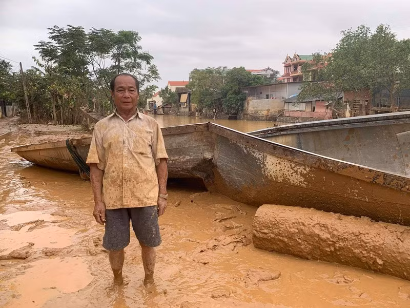Ông Bình cùng chiếc đò bị vỡ. Ảnh: Minh Quê.
