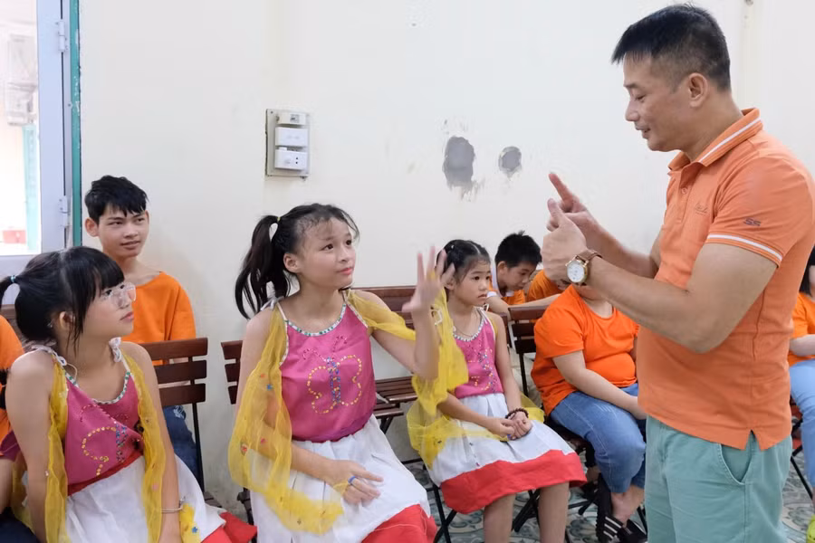 Thầy Sơn (ngoài cùng bên phải) trò chuyện với học trò bằng ngôn ngữ ký hiệu. Ảnh: TG Thầy Sơn (ngoài cùng bên phải) trò chuyện với học trò bằng ngôn ngữ ký hiệu. Ảnh: TG