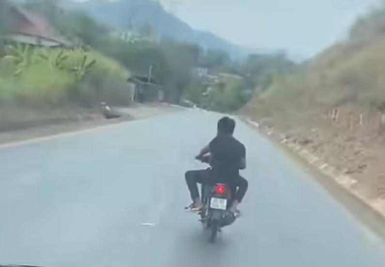 Hai thanh niên không đội mũ bảo hiểm điều khiển xe máy đánh võng trên Quốc lộ ngày 21/2.