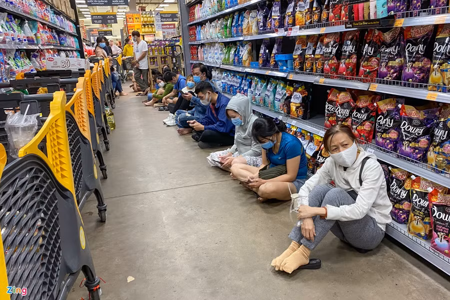 Nhiều người do chờ đợi quá lâu nên đã tranh thủ ngồi xuống đất để chờ tới lượt (Ảnh Zing.vn)