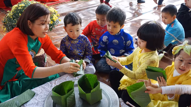 Học sinh học gói bánh chưng ngày Tết. Ảnh minh họa