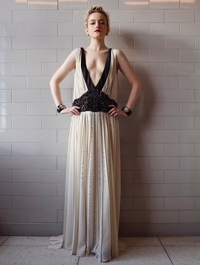 Giống như các vai diễn của Julia Garner, những bộ váy trên thảm đỏ cô diện luôn khác với chuẩn mực. Lần xuất hiện đầu tiên tại giải thưởng danh giá này, nữ diễn viên chọn thiết kế cổ khoét sâu màu đen - trắng từ nhà mốt Prada để thể hiện cá tính. Ngược lại, Elle Fanning có diện mạo nữ tính hơn khi diện bộ váy màu xanh ngọc của Gucci. Ảnh: WWD.