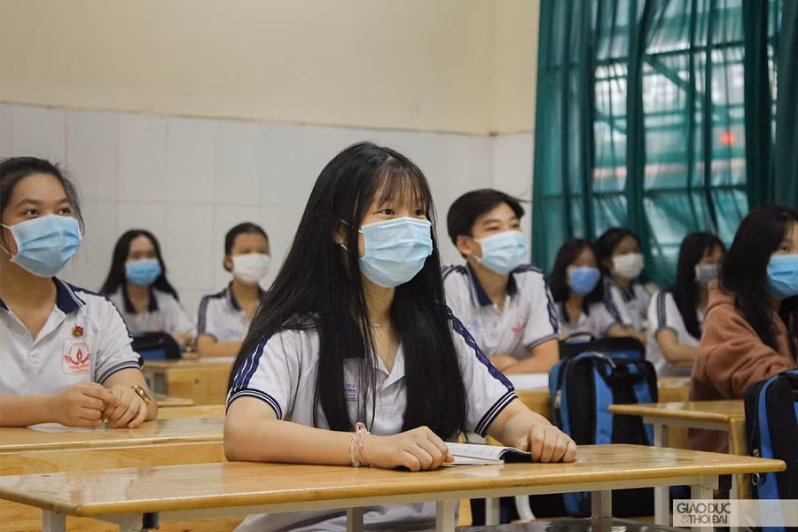 Học sinh đeo khẩu trang và giữ khoảng cách khi ngồi trong lớp.