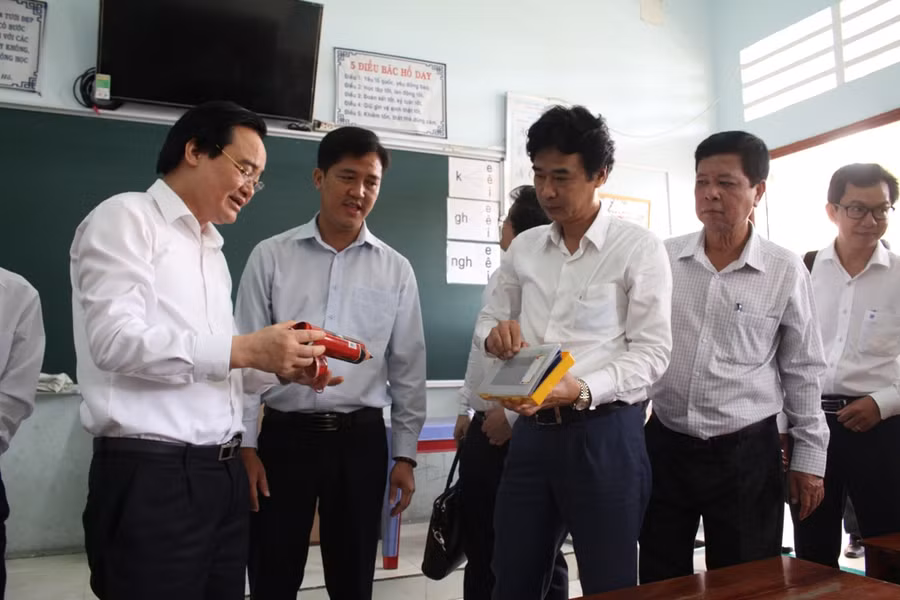 Bộ trưởng Phùng Xuân Nhạ cùng đoàn công tác kiểm tra dụng cụ học tập của học sinh.