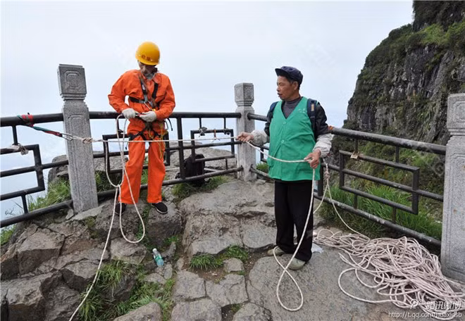Ông Bành kiểm tra lại dây thừng và thiết bị bảo hộ trước khi làm việc. a