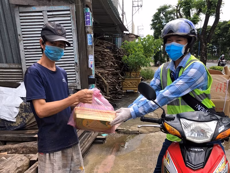 Giáo viên TPHCM mang sách giáo khoa đến nhà cho phụ huynh học sinh. Ảnh: Như Ý