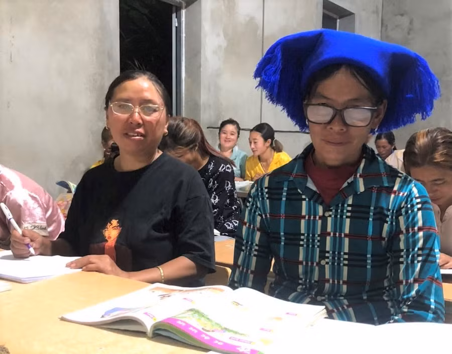 Bà Sần Ga Giê (bên phải) học viên cao tuổi nhất tại lớp xóa mù chữ bản Dền Thàng.