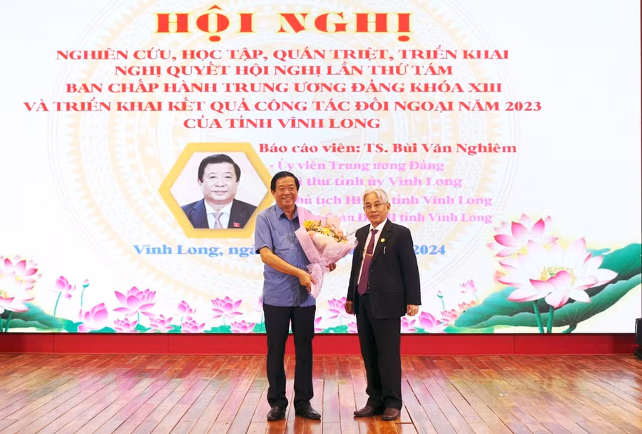 PGS.TS Lương Minh Cừ - Bí thư Đảng ủy, Hiệu trưởng Trường ĐH Cửu Long tặng hoa cho báo cáo viên.