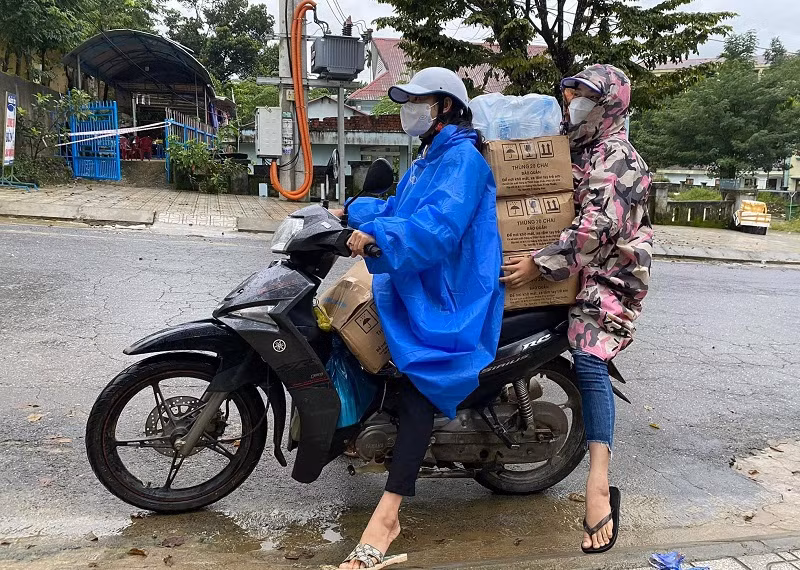 Cô Trà Thị Thu và Nguyễn Việt Thảo vận chuyển hàng hóa hỗ trợ cho các hộ dân thực hiện cách ly y tế.