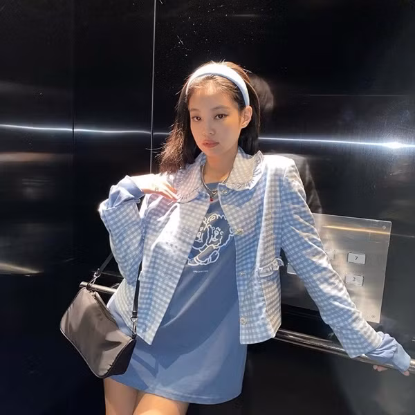 Jennie kết hợp chiếc áo khoác kẻ caro màu xanh ngọt ngào với áo nỉ in hình, tôn khéo đôi chân tôn cùng vẻ ngoài trẻ trung.