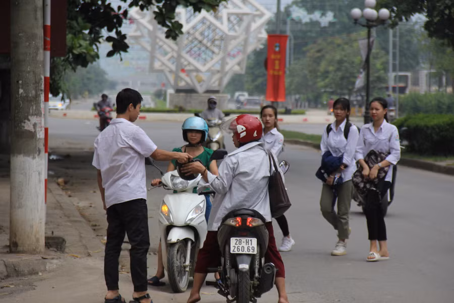 Phụ huynh đưa thí sinh đến điểm thi từ rất sớm và không quên dặn dò con em trước khi bước vào phòng thi.
