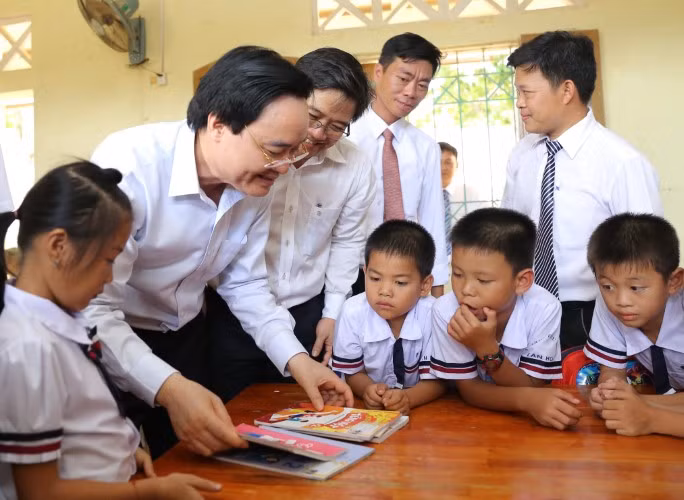 Bộ trưởng Phùng Xuân Nhạ chia sẻ, động viên thầy và trò xã Tân Hóa (Minh Hóa, Quảng Bình) vượt qua khó khăn sau trận lũ lớn xảy ra vào đầu năm học 2019 - 2020. Ảnh: TL