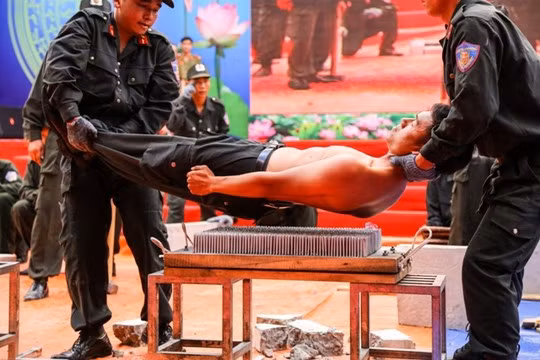 Sau khi vận công, người chiến sĩ trẻ cho đồng đội khiên mình đặt lên bàn đinh nhọn