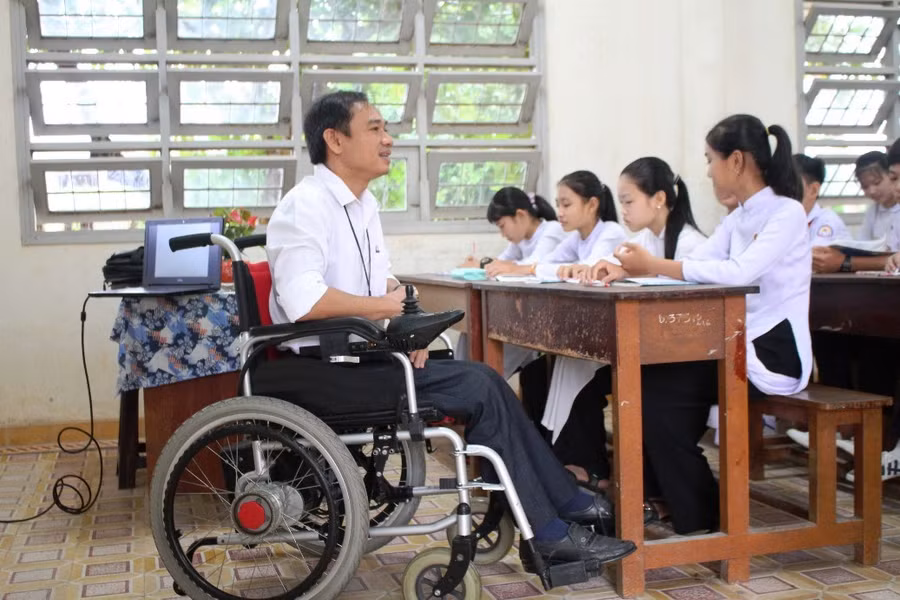 Thầy Thái Thành Thuận đang giảng bài trên chiếc xe lăn điện.