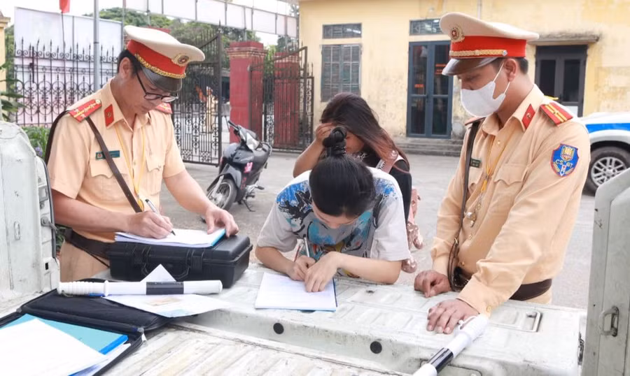 Lực lượng CSGT lập biên bản xử lý học sinh vi phạm.