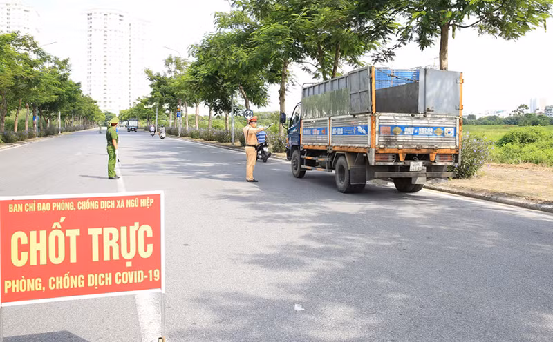 Lực lượng chức năng chốt trực trên địa bàn xã Ngũ Hiệp, huyện Thanh Trì kiểm tra giấy đi đường của người tham gia giao thông.