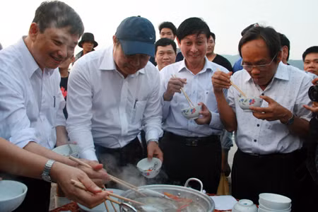 Ông Huỳnh Đức Thơ (đội mũ) yêu cầu cán bộ Đà Nẵng phải ăn cá để làm gương cho người dân và du khách an tâm.