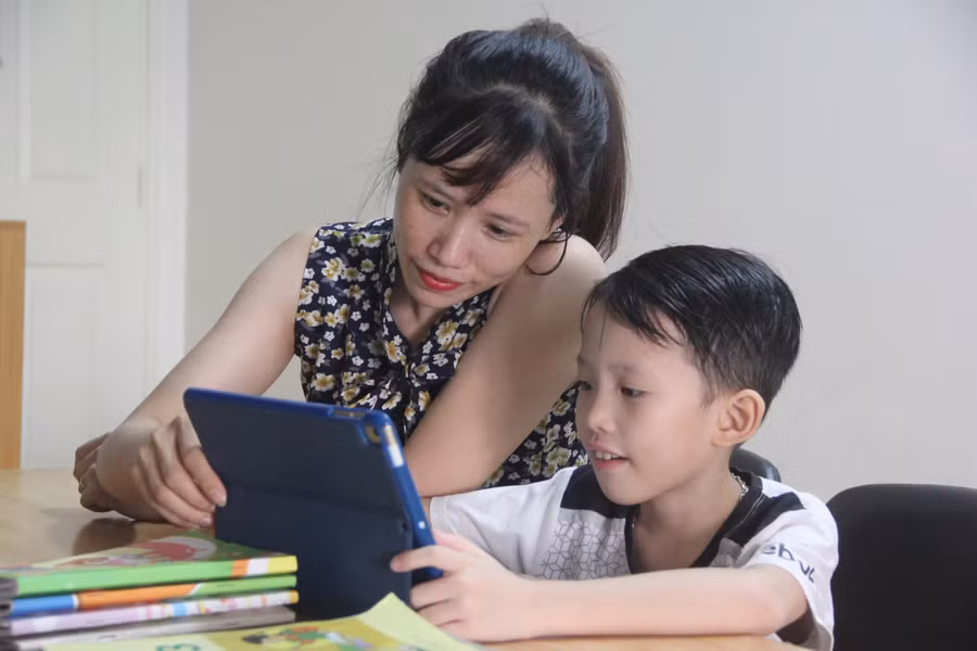 Phụ huynh tại TP.HCM hướng dẫn con học trực tuyến trong đợt nghỉ phòng dịch hồi tháng 4/2020. Ảnh minh hoạ
