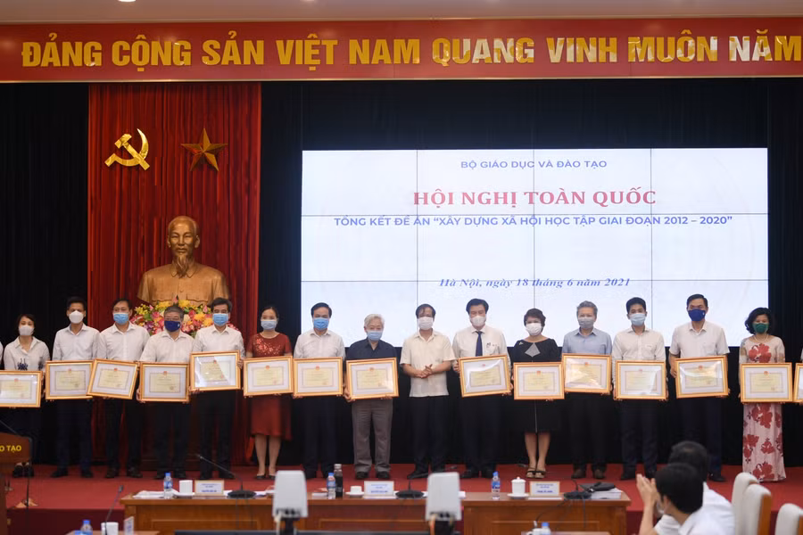 Bộ trưởng Bộ GD&ĐT Nguyễn Kim Sơn trao bằng khen của Bộ trưởng Bộ GD&ĐT cho các tập thể, cá nhân có thành tích xuất sắc trong công tác triển khai thực hiện Đề án “Xây dựng xã hội học tập” giai đoạn 2012 - 2020.