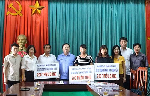 Đại diện lãnh đạo ngành GDĐT Hà Nội trao hỗ trợ cho các trường bị ngập úng của huyện Chương Mỹ