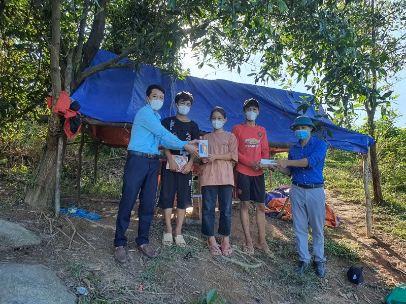 Phóng viên Báo GD&amp;TĐ (ngoài cùng bên trái) trao tặng 2 điện thoại cho em Hồ Thị Nguyệt và Hồ Văn Thông từ ủng hộ của các nhà hảo tâm. Ảnh: TG