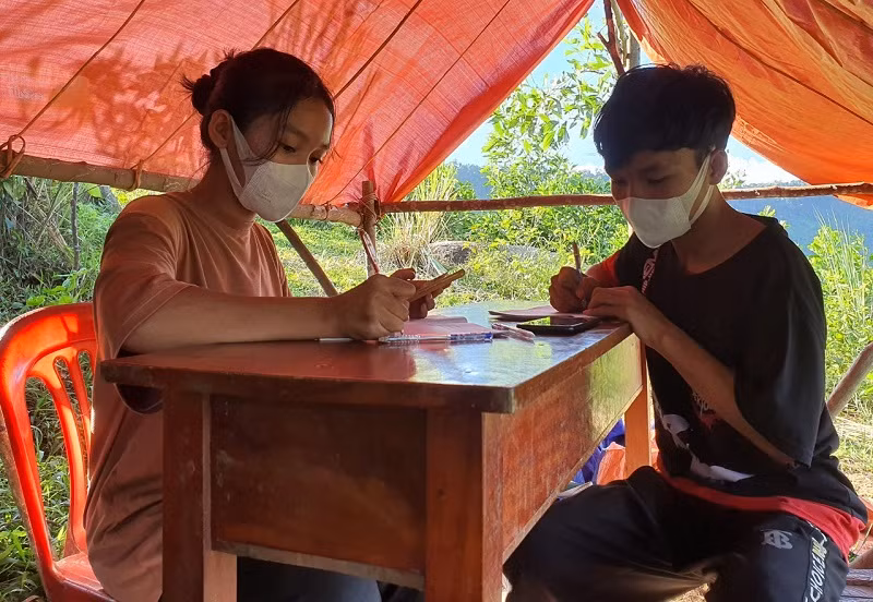 Học sinh ở bản Rào Con băng rừng lên tận đỉnh núi, đón sóng học trực tuyến. Ảnh: TG