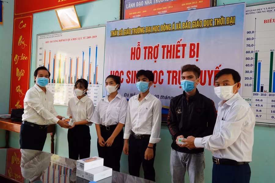 Đại diện Trường ĐH Đông Á ùng với Ban giám hiệu Trường THPT Phạm Phú Thứ trao thiết bị học trực tuyến cho HS người dân tộc Cơ Tu của nhà trường