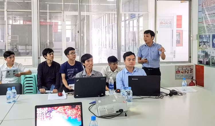 TS Nguyễn Ngọc Sơn (đứng) thuộc nhóm NCM của Trường ĐH Công nghiệp TPHCM đang thảo luận đề tài. Ảnh: TG