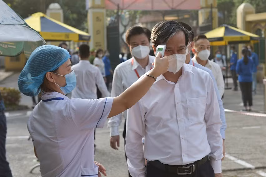 Bộ trưởng đo thân nhiệt tại điểm thi Trường THPT Chu Văn An, Hà Nội.