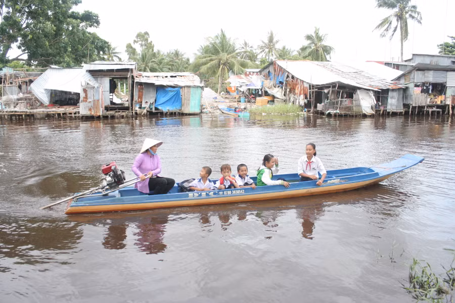 Học sinh huyện Trần Văn Thời (Cà Mau) đến trường bằng xuồng máy. Ảnh: Q. Ngữ