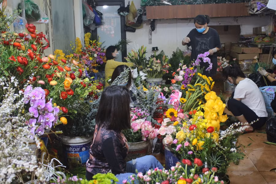 Chủ cơ sở hoa Hồng Nhung, phố Kim Ngưu huy động nhân viên làm thêm giờ để cắm hoa theo đơn của khách.