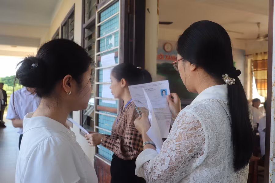 Cán bộ coi thi tại điểm thi Trường THPT Trần Phú đối chiếu thông tin của thí sinh khi gọi thí sinh vào phòng thi. Cán bộ coi thi tại điểm thi Trường THPT Trần Phú đối chiếu thông tin của thí sinh khi gọi thí sinh vào phòng thi.