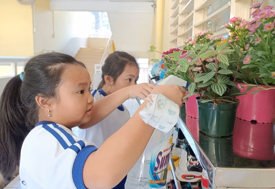 Học sinh Trường Tiểu học Nguyễn Bỉnh Khiêm chăm sóc cây cảnh tại không gian trước lớp học.