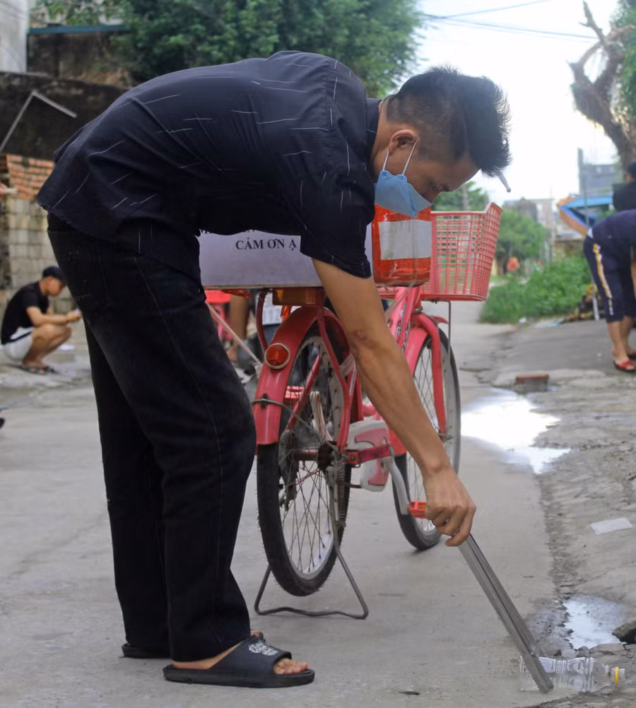 Anh Nguyễn Văn Nam nhặt lon chai rơi trên đường tại xã Minh Lộc (Hậu Lộc, Thanh Hóa).