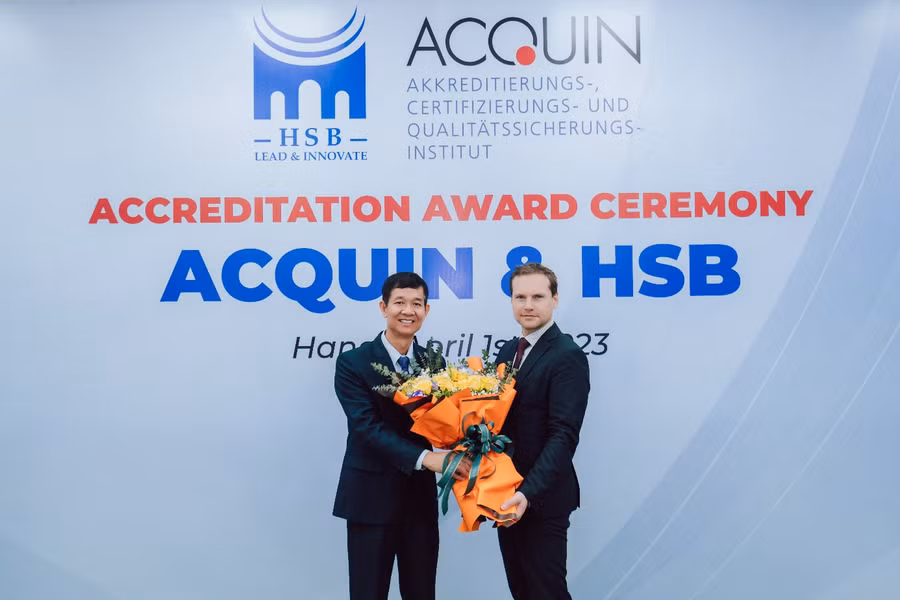PGS.TS. Hoàng Đình Phi, Hiệu trưởng Trường Quản trị và Kinh doanh (bên trái) và đại diện Acquin. PGS.TS. Hoàng Đình Phi, Hiệu trưởng Trường Quản trị và Kinh doanh (bên trái) và đại diện Acquin.