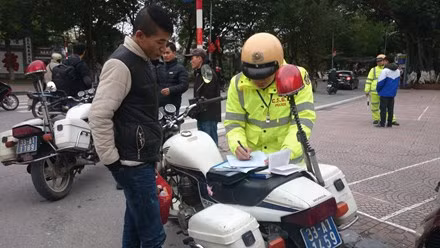 Lực lượng CSGT lập biên bản xử phạt người đi bộ.